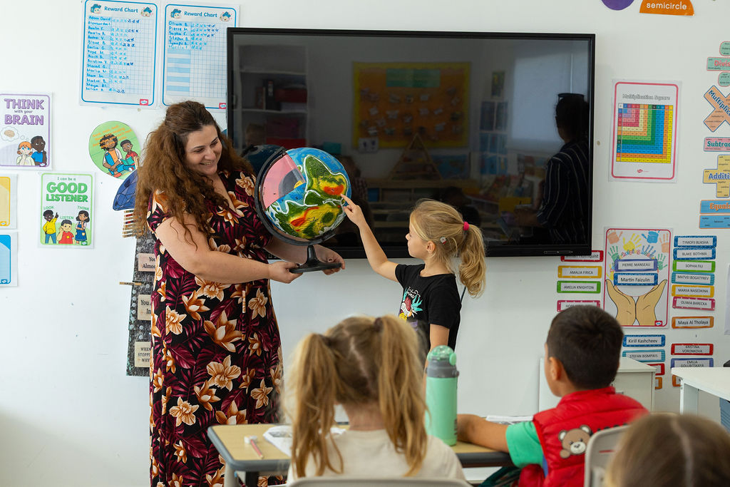 Teacher guiding young students symbolising the mission of a Limassol private school to provide quality education and personal growth in Cyprus