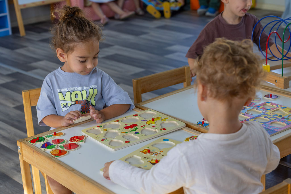 Children exploring wooden puzzles together at Golden Oak.